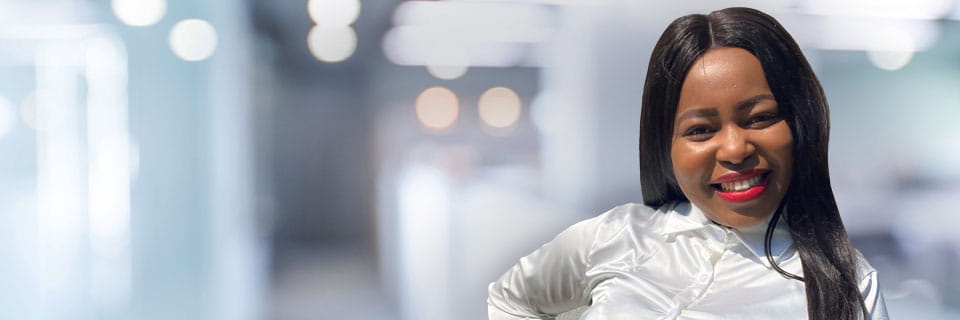 Black female with white blouse smiling at the photographer